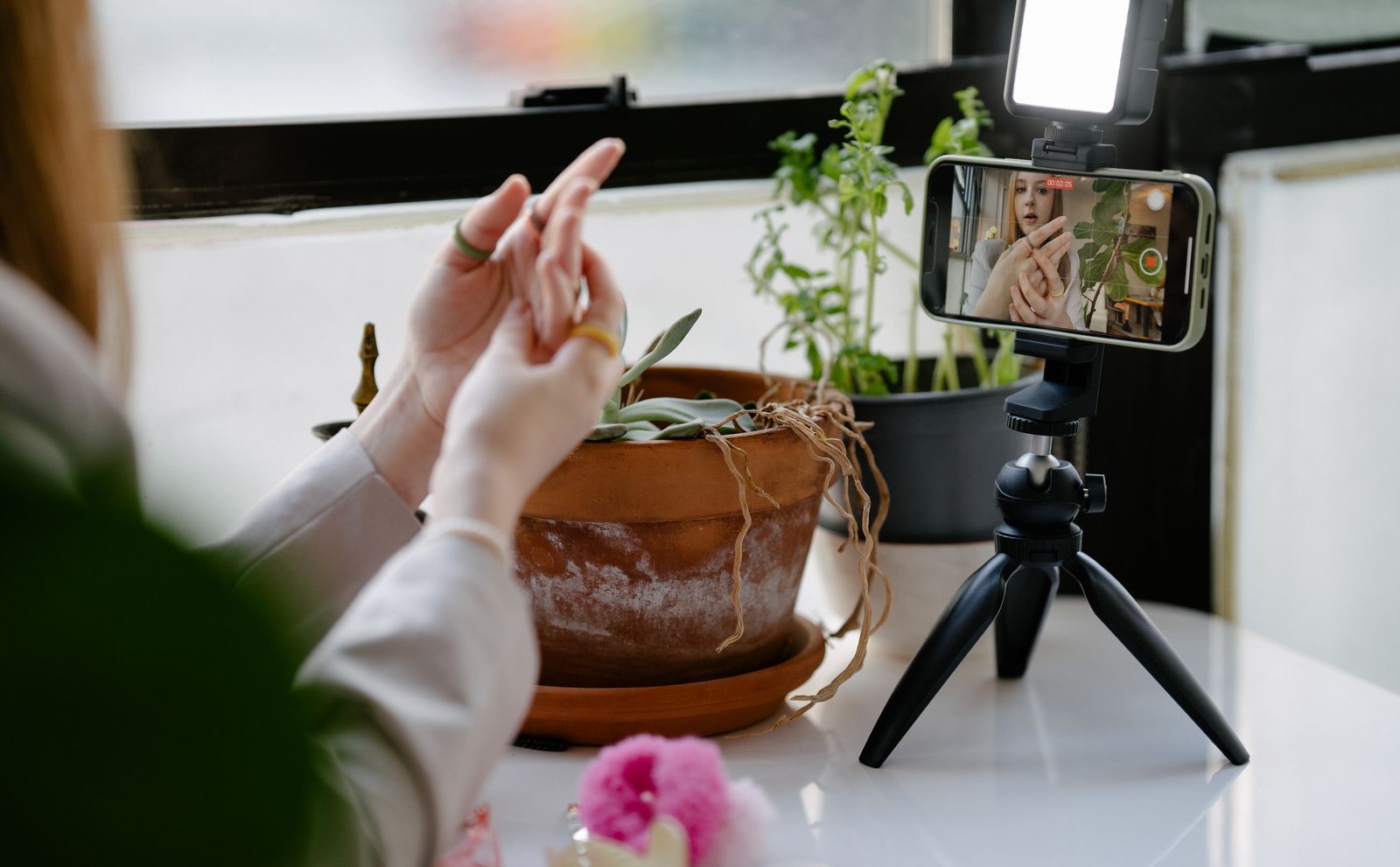 Người trẻ ở nhà quay video bằng điện thoại gắn trên tripod, ánh sáng ấm